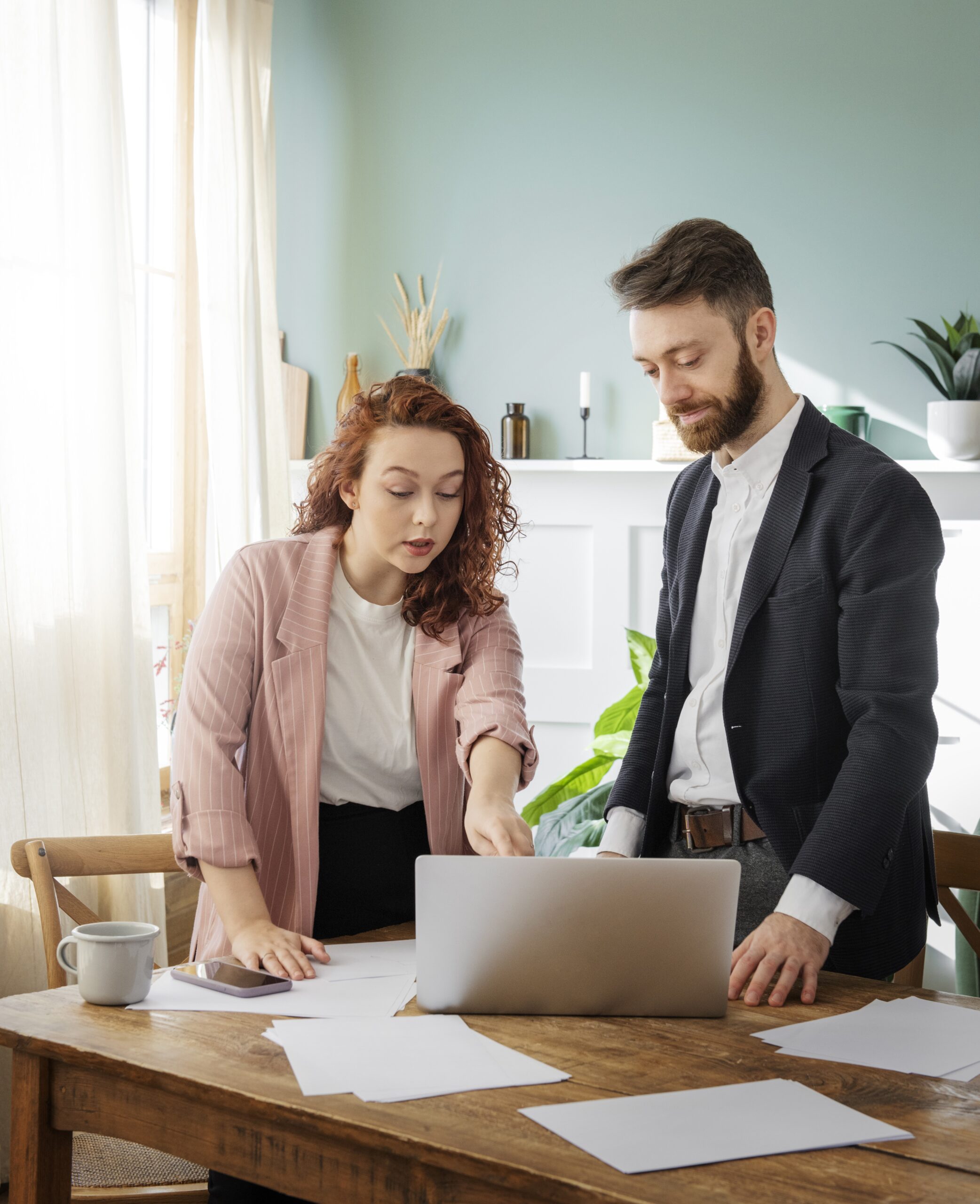 a man and a woman working and woman explaining to man about something from laptop